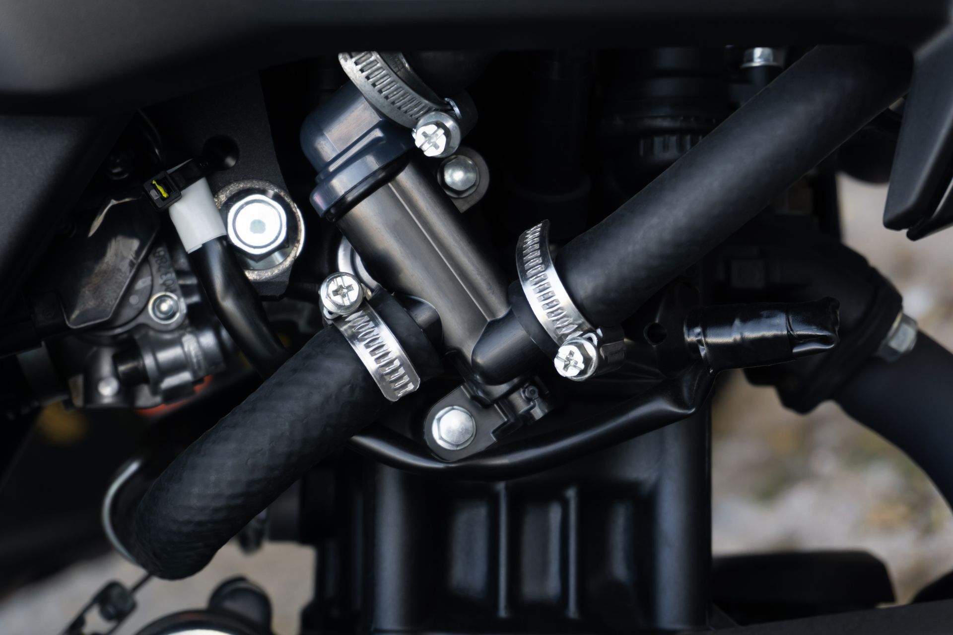 Un primer plano de un motor de motocicleta con abrazaderas de manguera