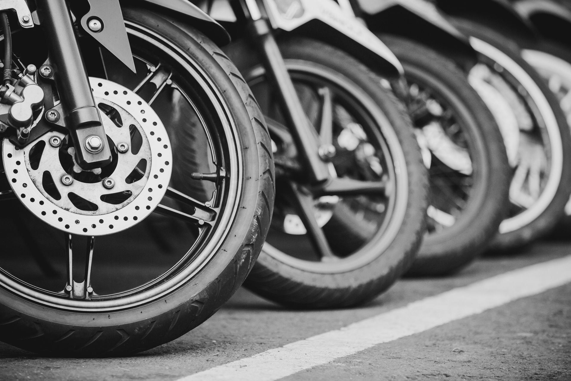 Una fotografía en blanco y negro de una fila de motocicletas estacionadas una al lado de la otra.