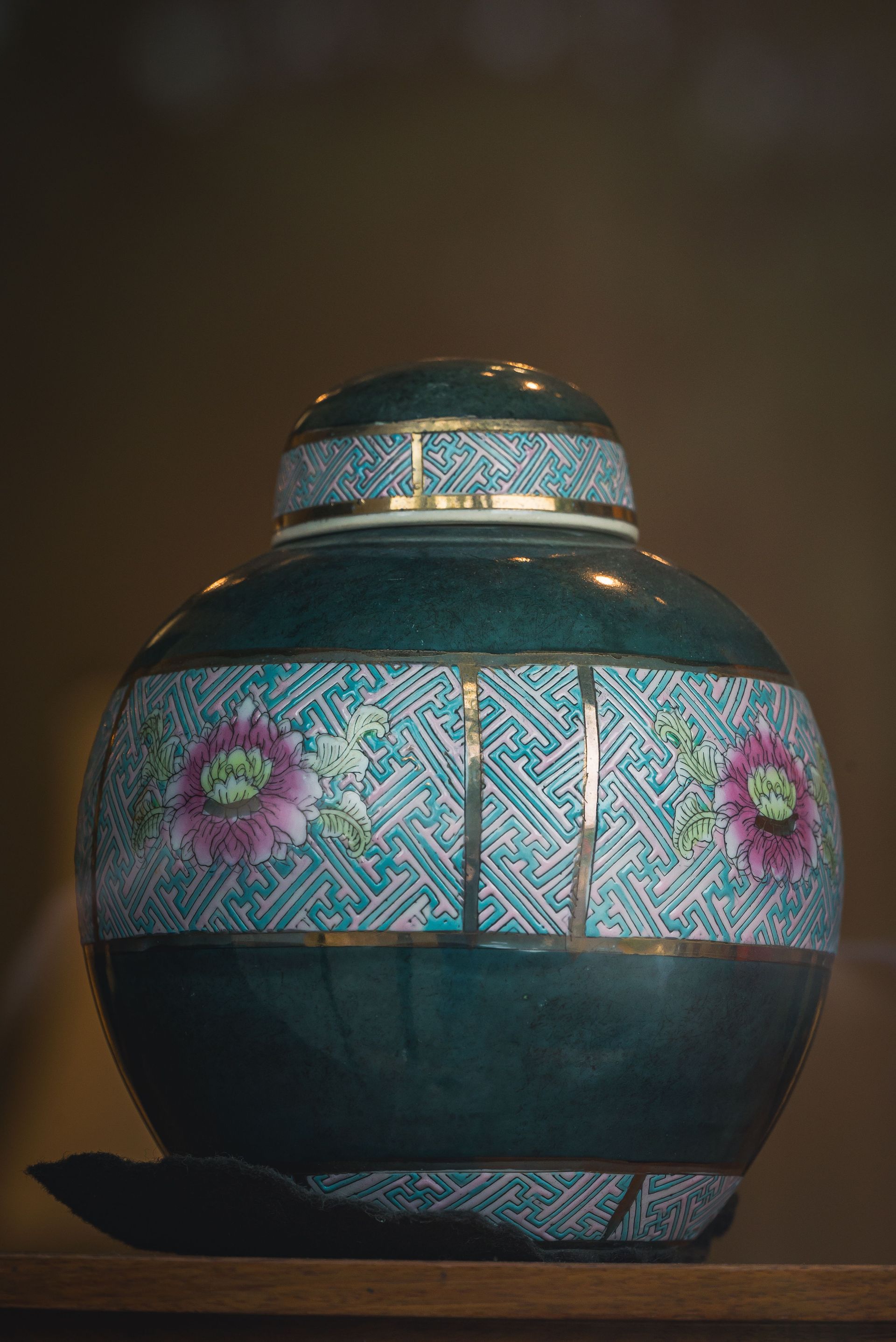 A black can is sitting on a table next to a vase of flowers.