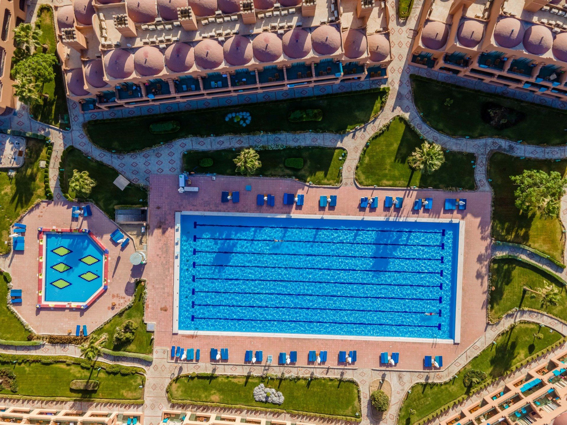 An aerial view of a large swimming pool surrounded by buildings