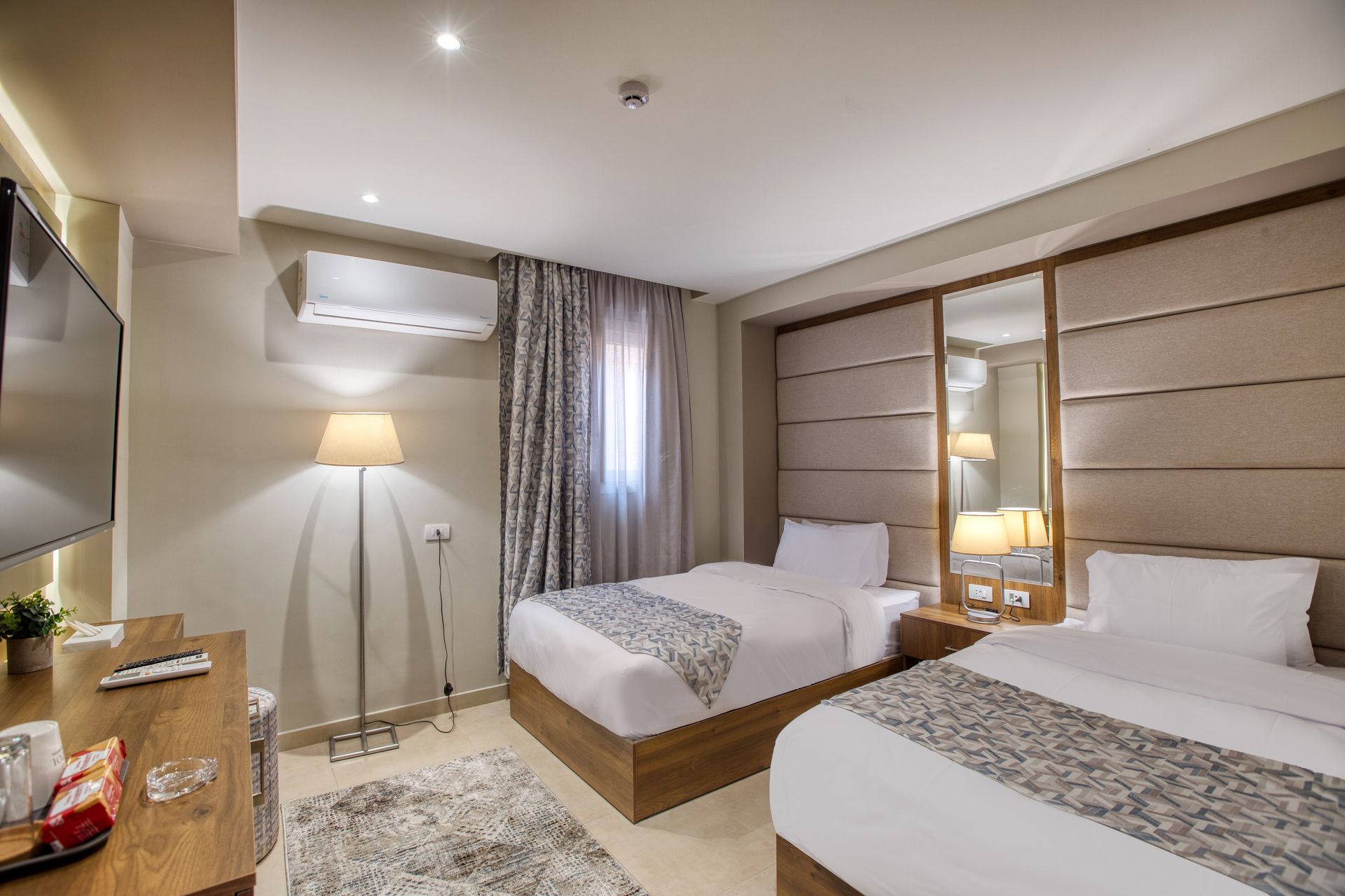 A hotel room with two beds and a flat screen tv.