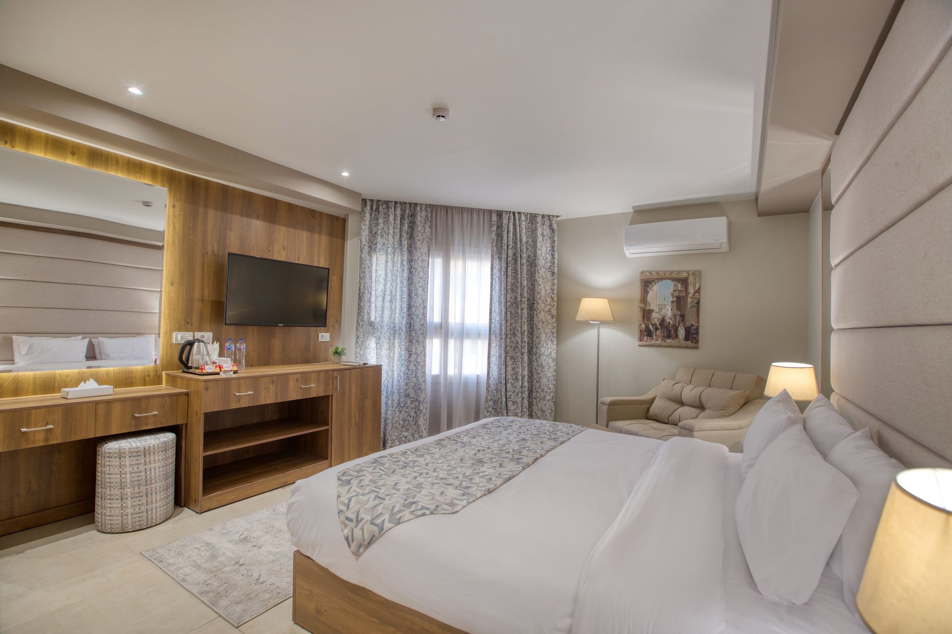 A hotel room with a king size bed and a flat screen tv.