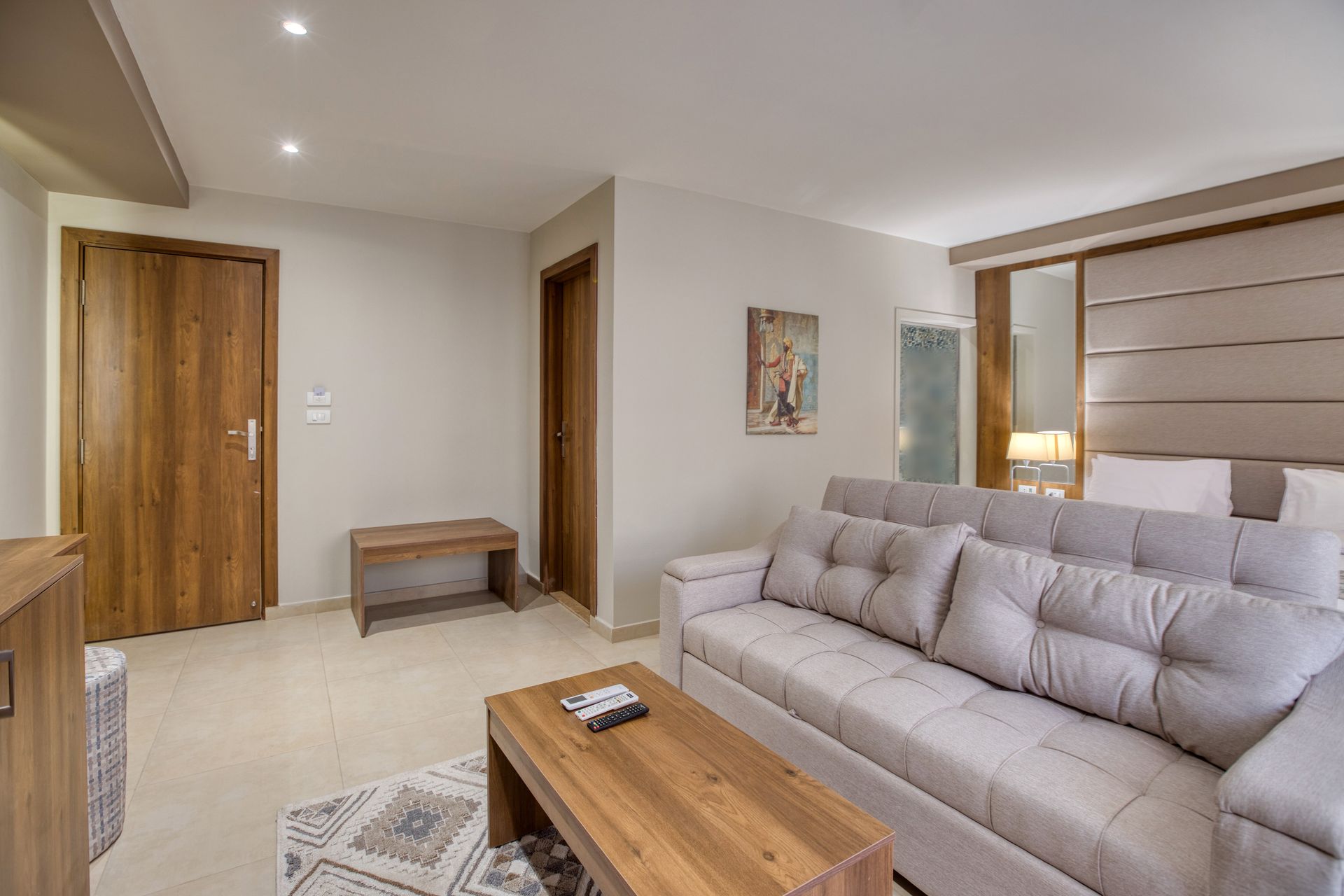 A living room with a couch and a coffee table in a hotel room.