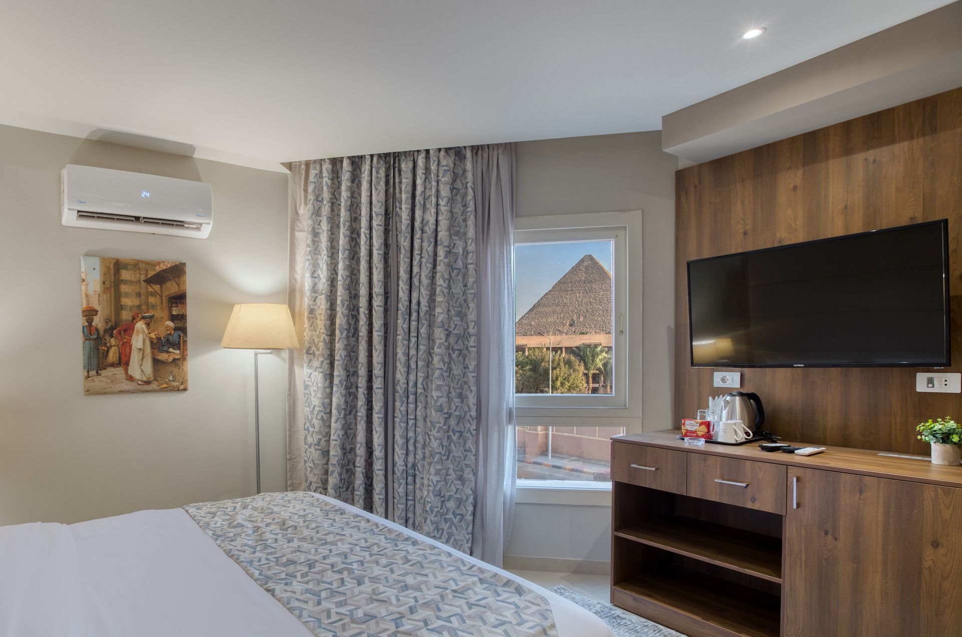 A hotel room with a bed , television , and window.