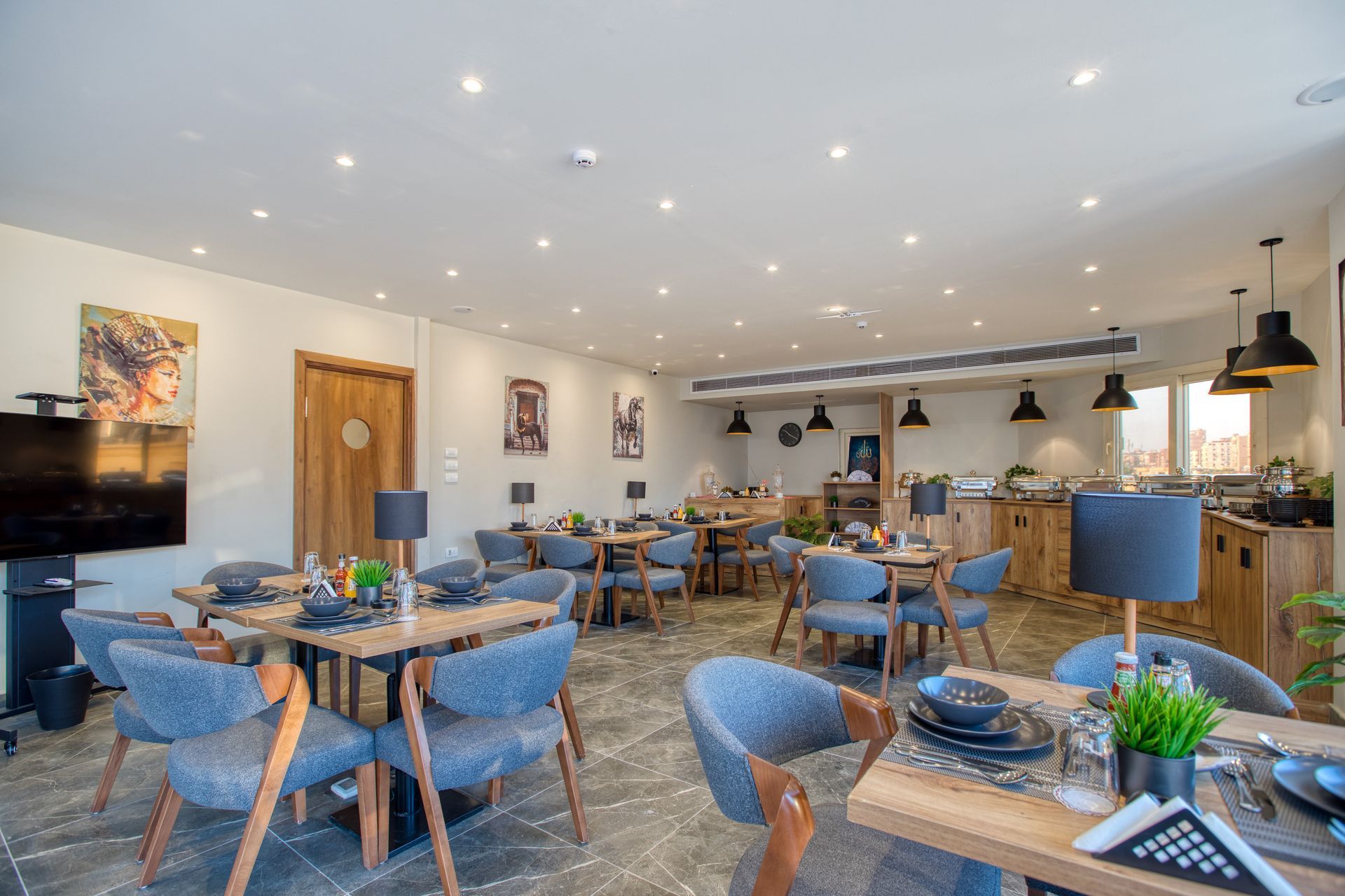 A large dining room with tables and chairs and a flat screen tv.