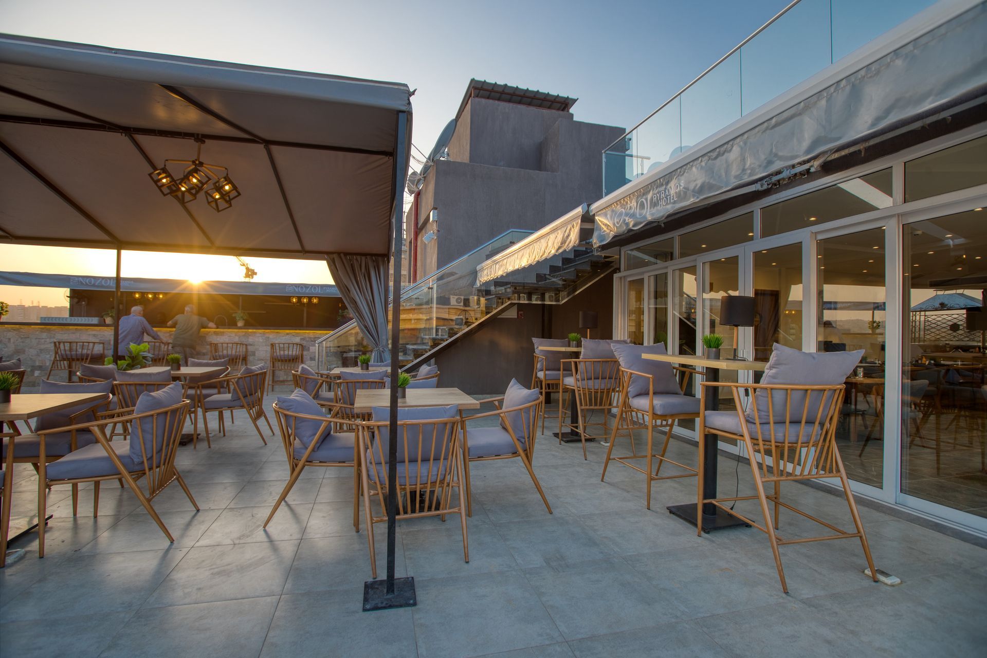 A patio with tables and chairs and a canopy.