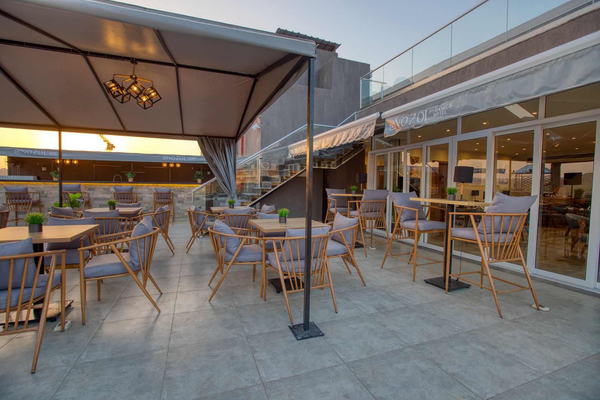 A patio with tables and chairs and umbrellas in front of a building.