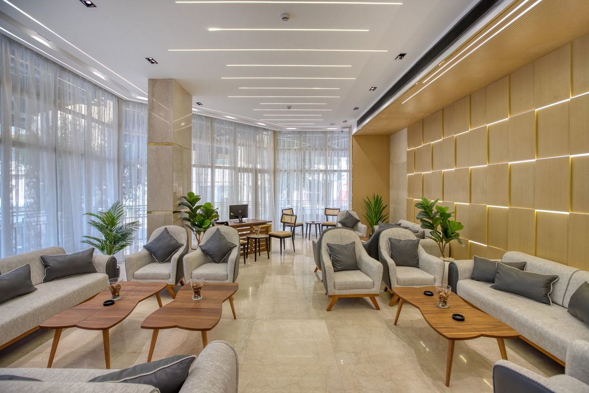 A living room filled with furniture and tables in a hotel.