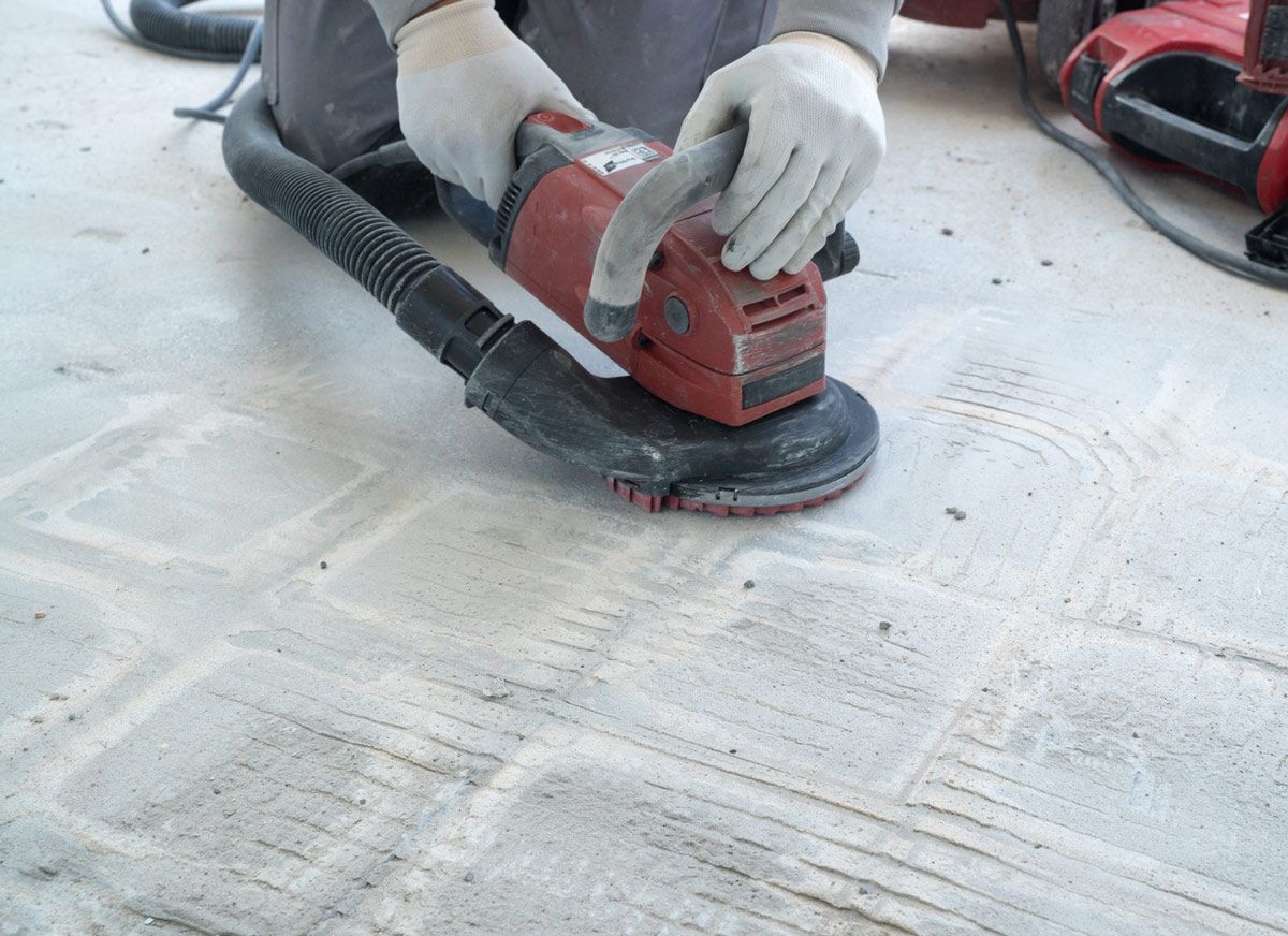 A Person Using a Grinder on A Concrete Floor — Petone, Waikato — Industrial Floor Care