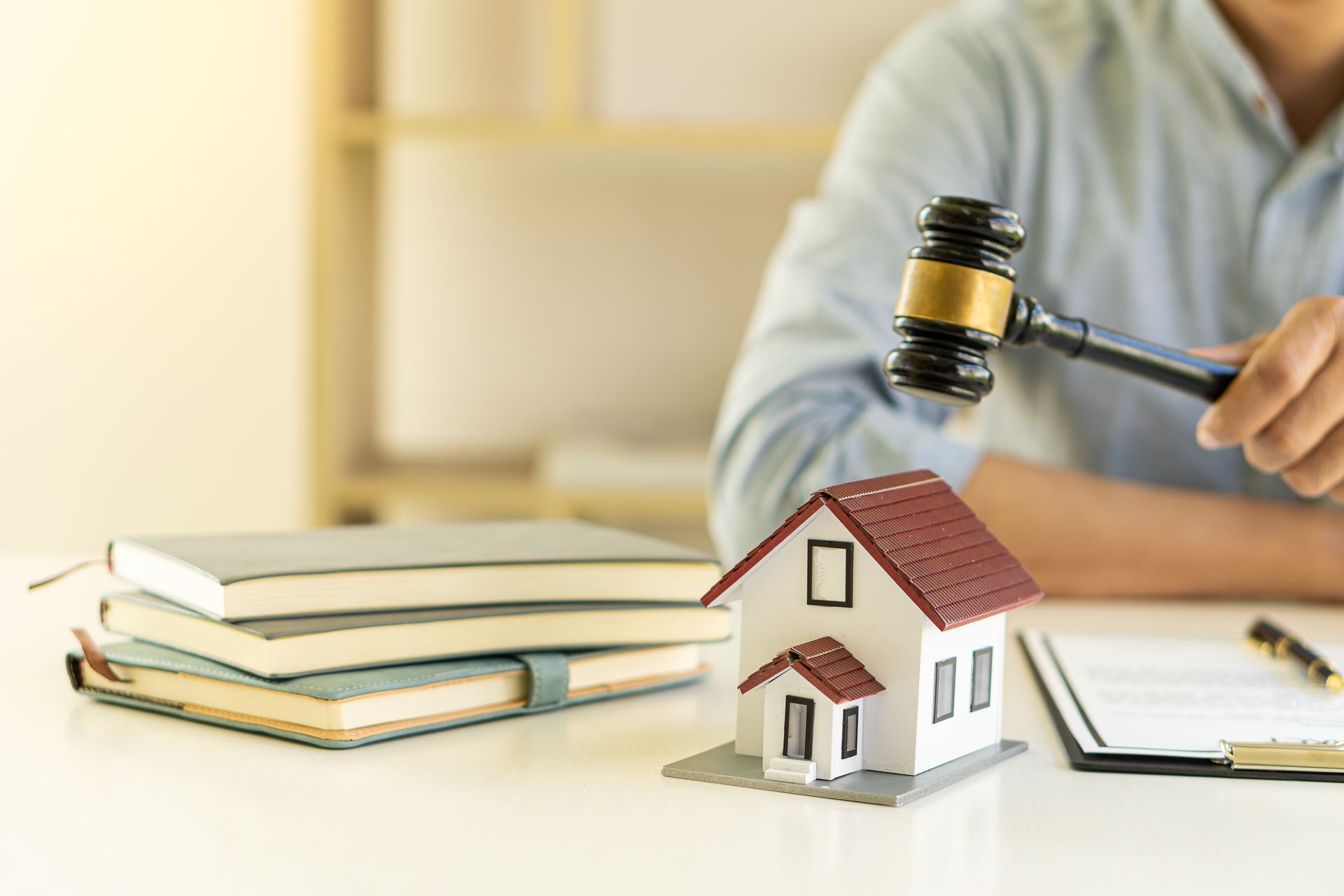 Real estate agent holding a hammer to break the house.