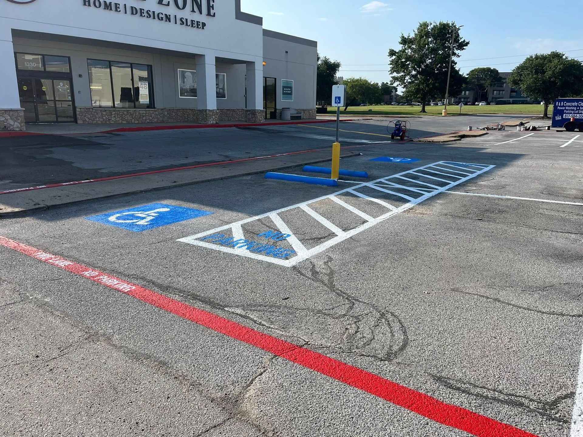 Handicap parking space with blue and white markings, yellow pole.