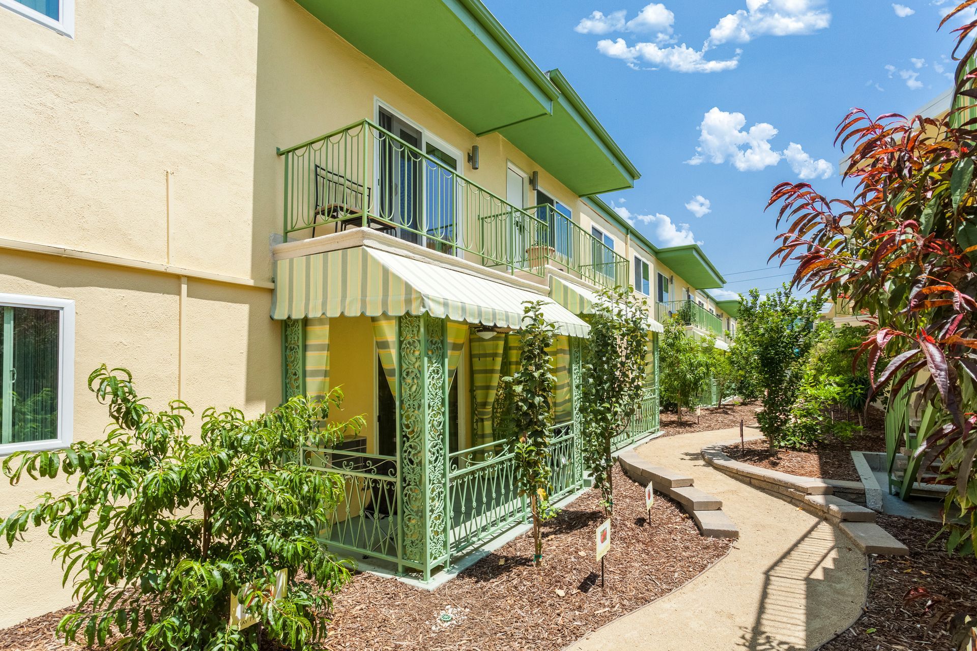 A building with a green roof and a white awning on the porch.