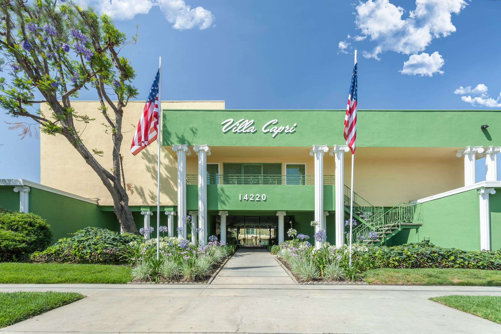 A large green building with a staircase leading up to it