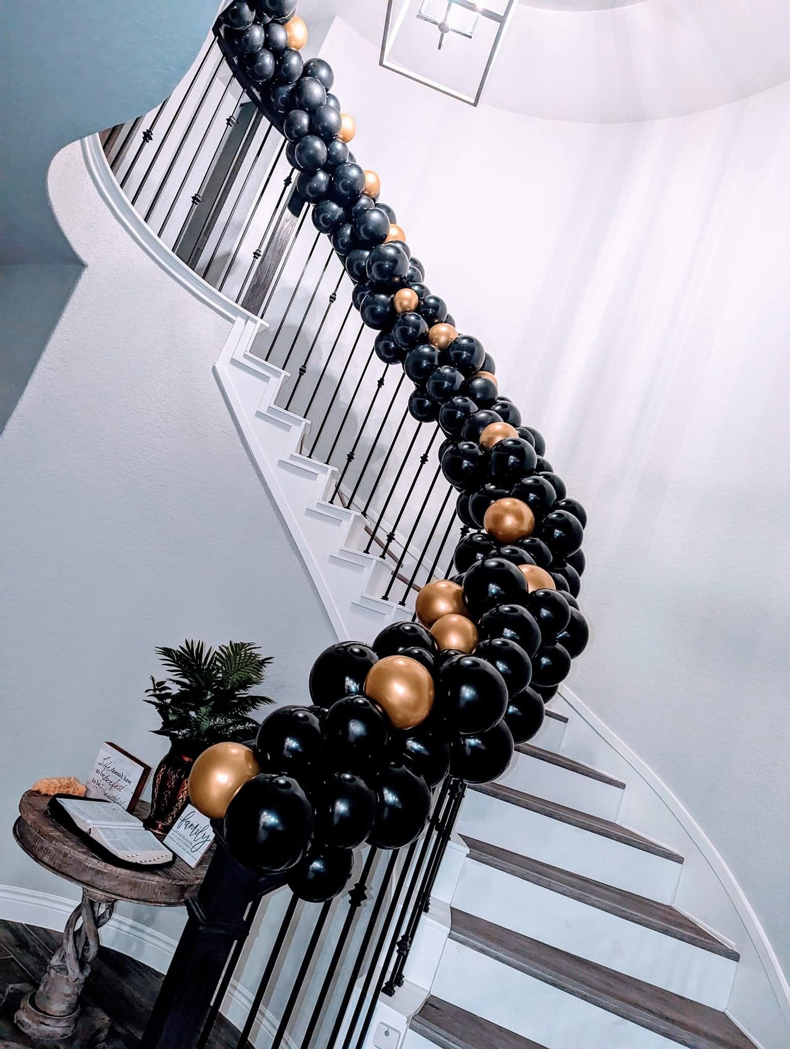 Black and gold beaded necklace draped over a white striped mannequin display