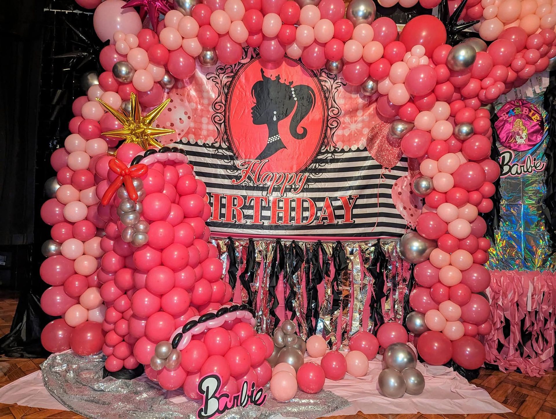 Pink balloon arch with a central horse logo and “Birthday” sign, decorated event backdrop