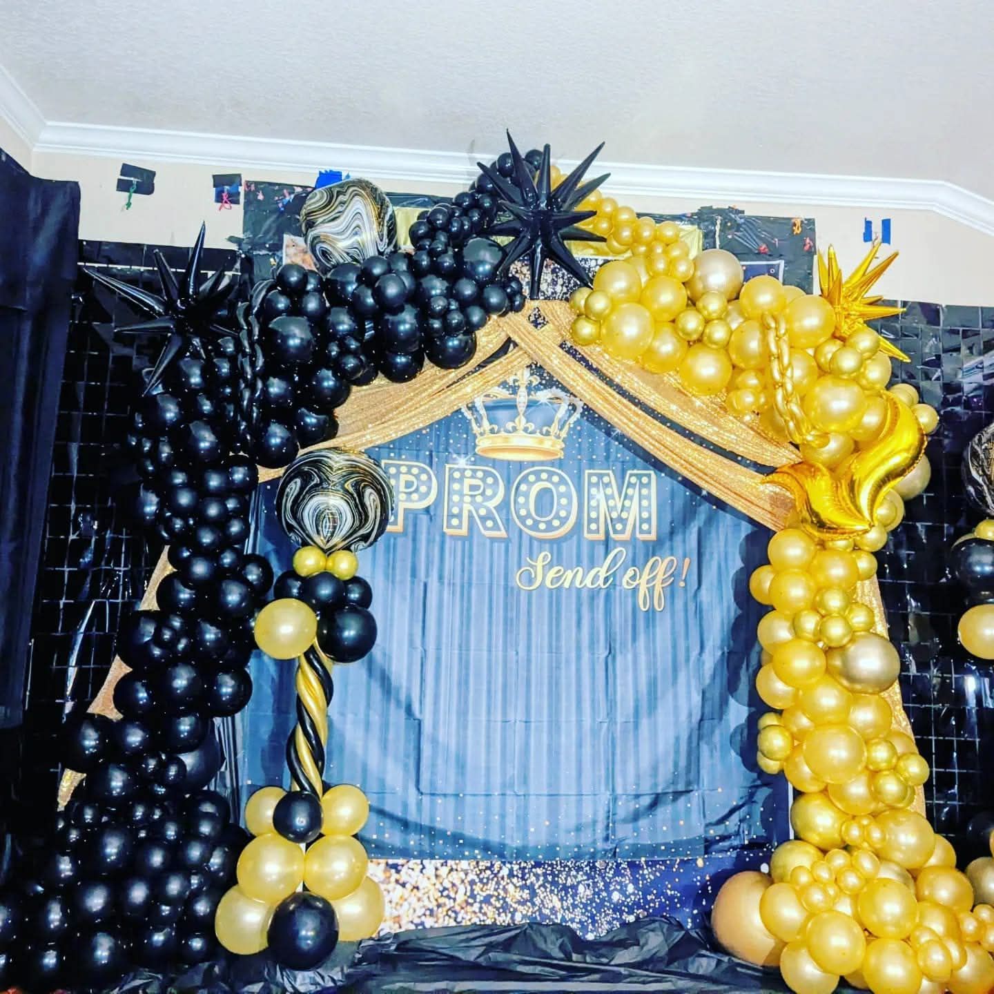 Blue and gold balloon arch framing a “PROM send off” backdrop with balloons and star accents
