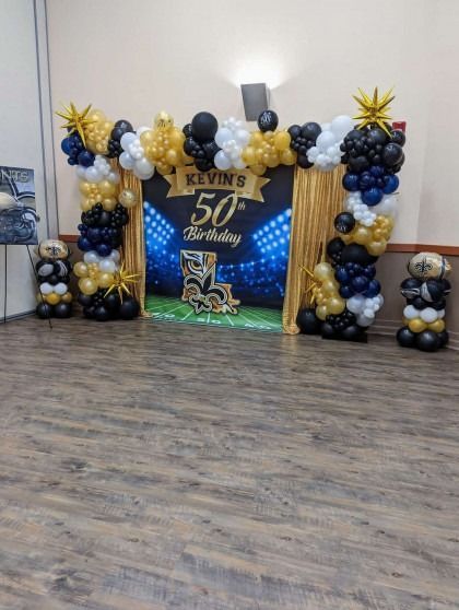 50th birthday balloon backdrop in gold, black, and silver with a large “Kevin 50” sign