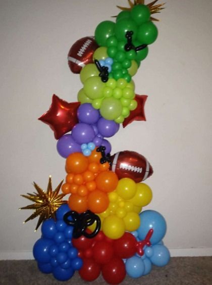 Colorful balloon sculpture of a dragon-like figure on a plain background