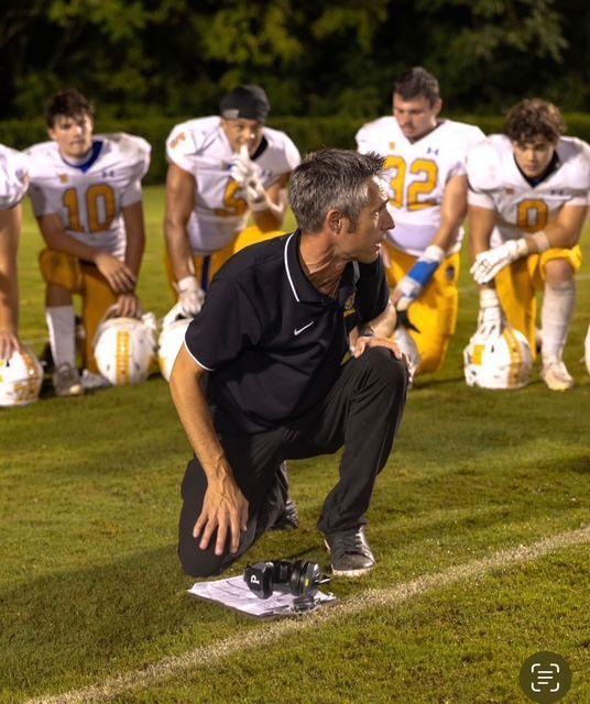 TR Athletics coach with student-athlete on the sideline