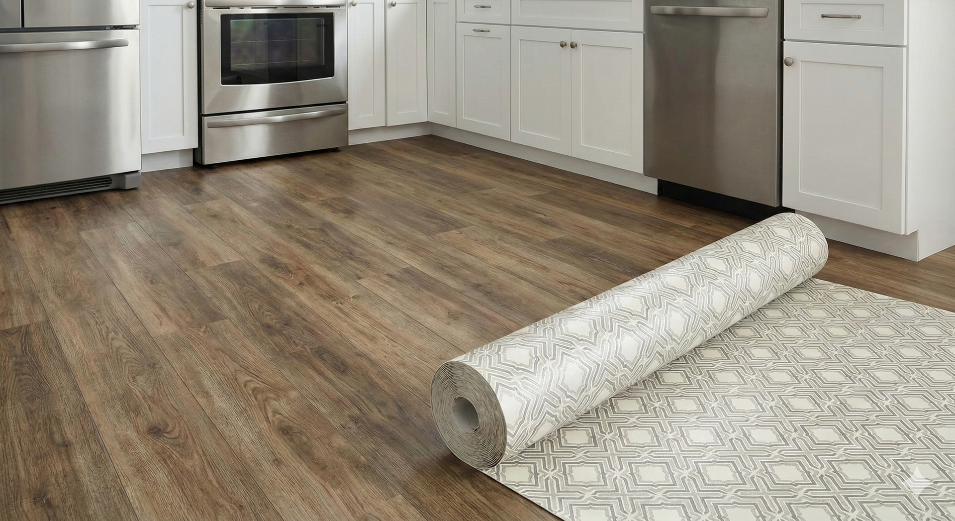 Kitchen with wood-look floor, stainless steel appliances, and rolled-up patterned rug.
