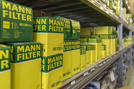 File di scatole gialle di filtri Mann sugli scaffali del magazzino