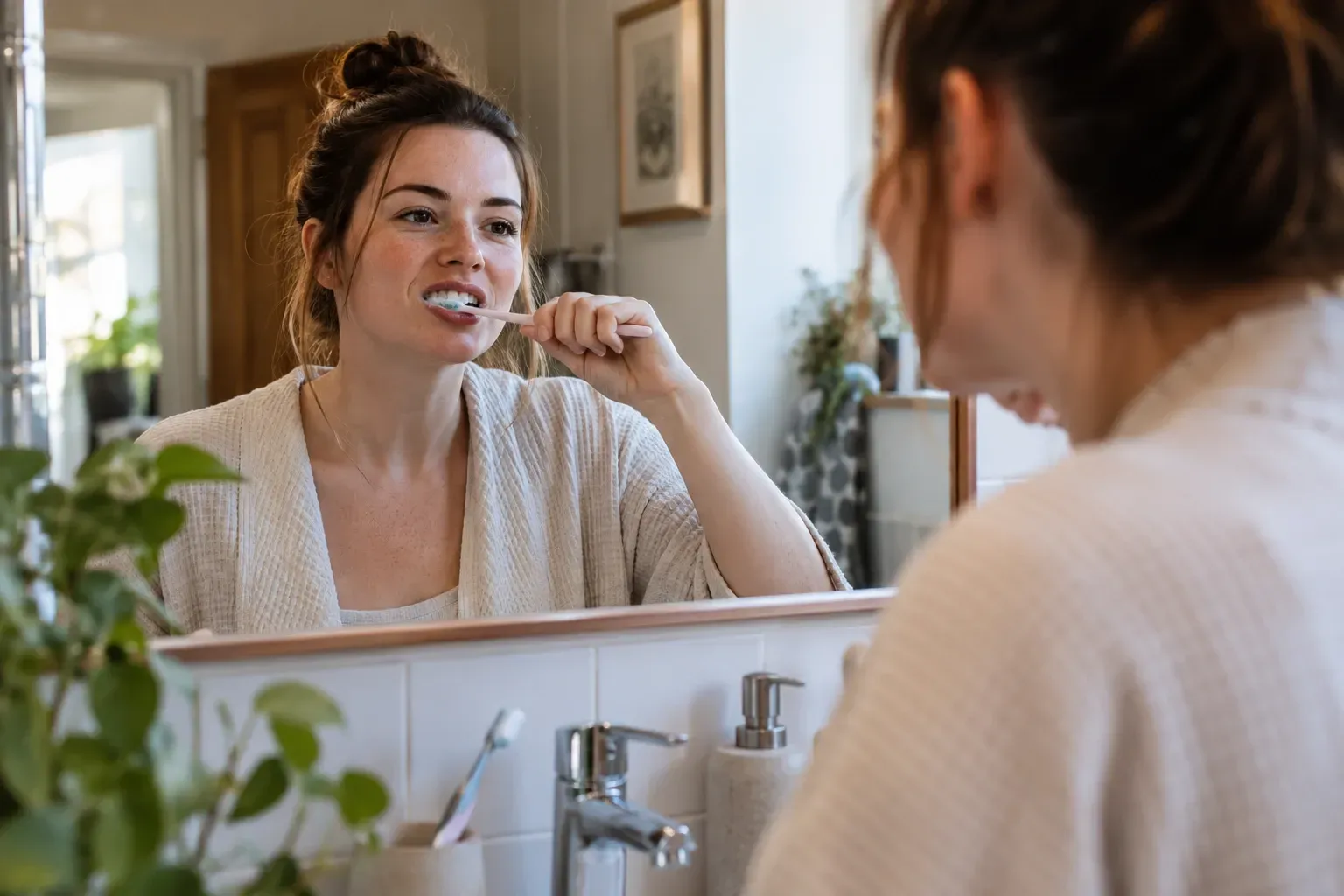 Illustrative image of an adult brushing their teeth at home as part of everyday bonding aftercare
