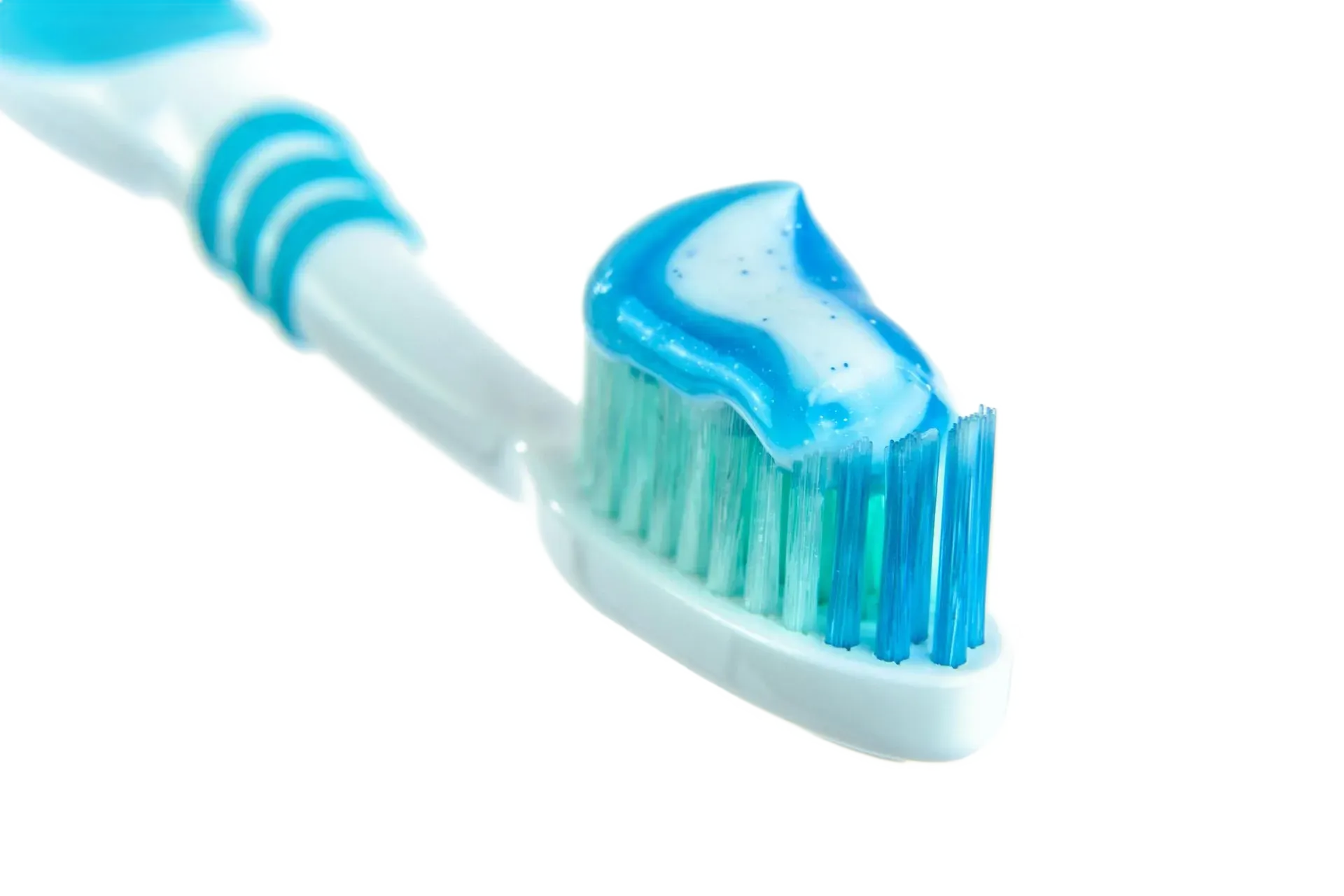 Manual toothbrush with blue and white toothpaste, oral hygiene tips from a dentist near Southampton