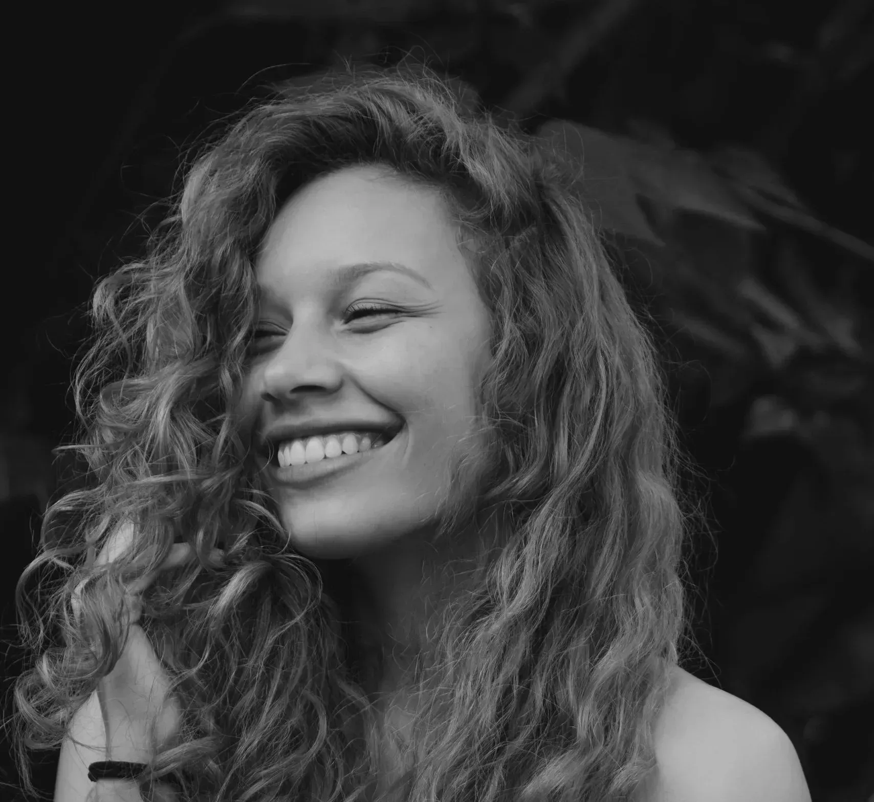 Woman with curly hair laughing with a bright, healthy smile near Southampton