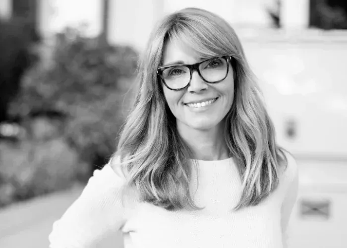 Smiling woman in glasses outdoors, a patient at a dentist near Southampton