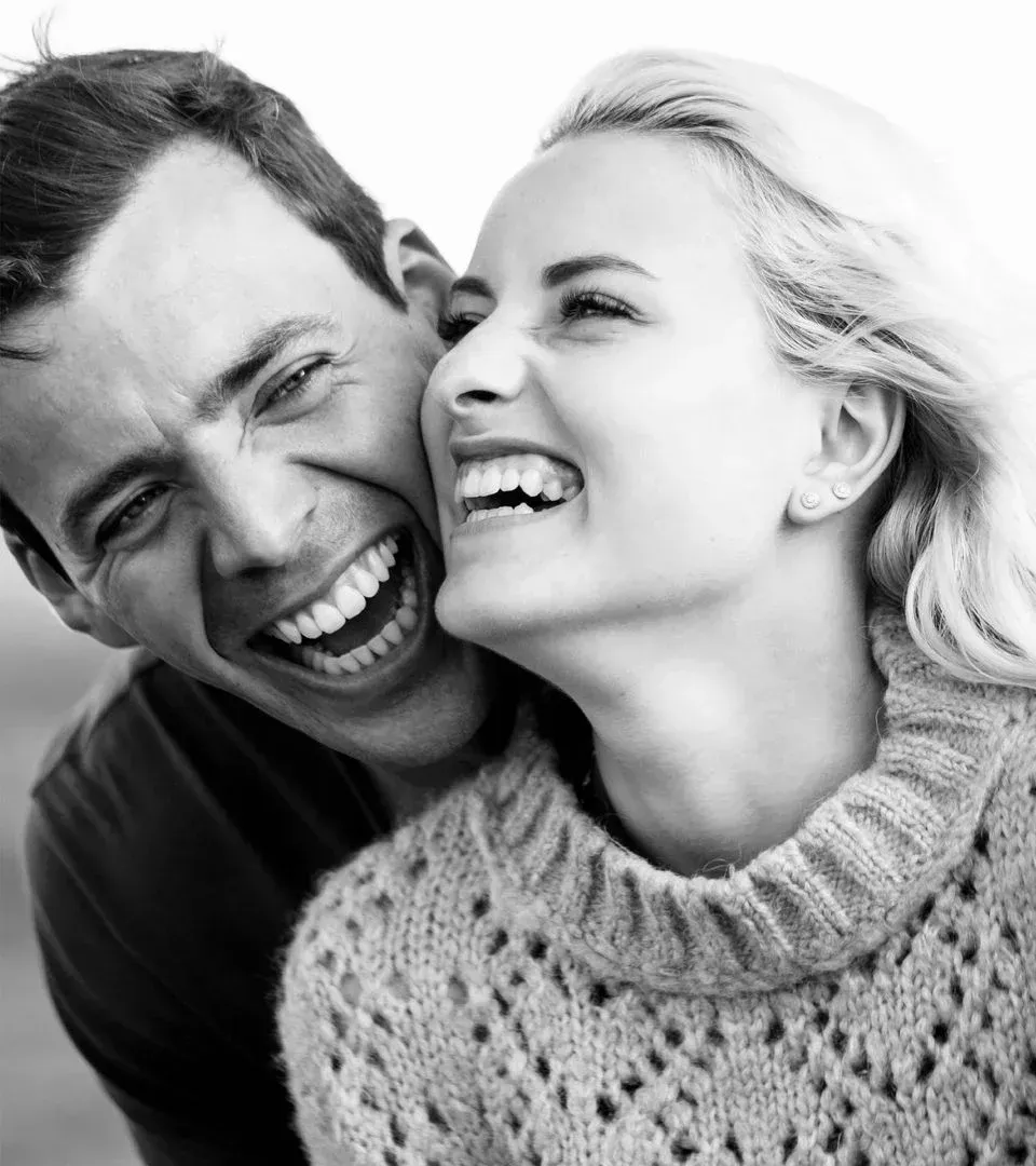 Happy couple laughing with bright healthy smiles after cosmetic dentistry near Southampton