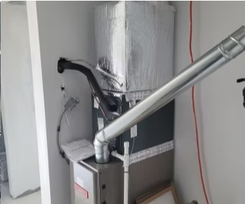 Metal furnace and silver ductwork in a small utility room, with a black hose and white walls.