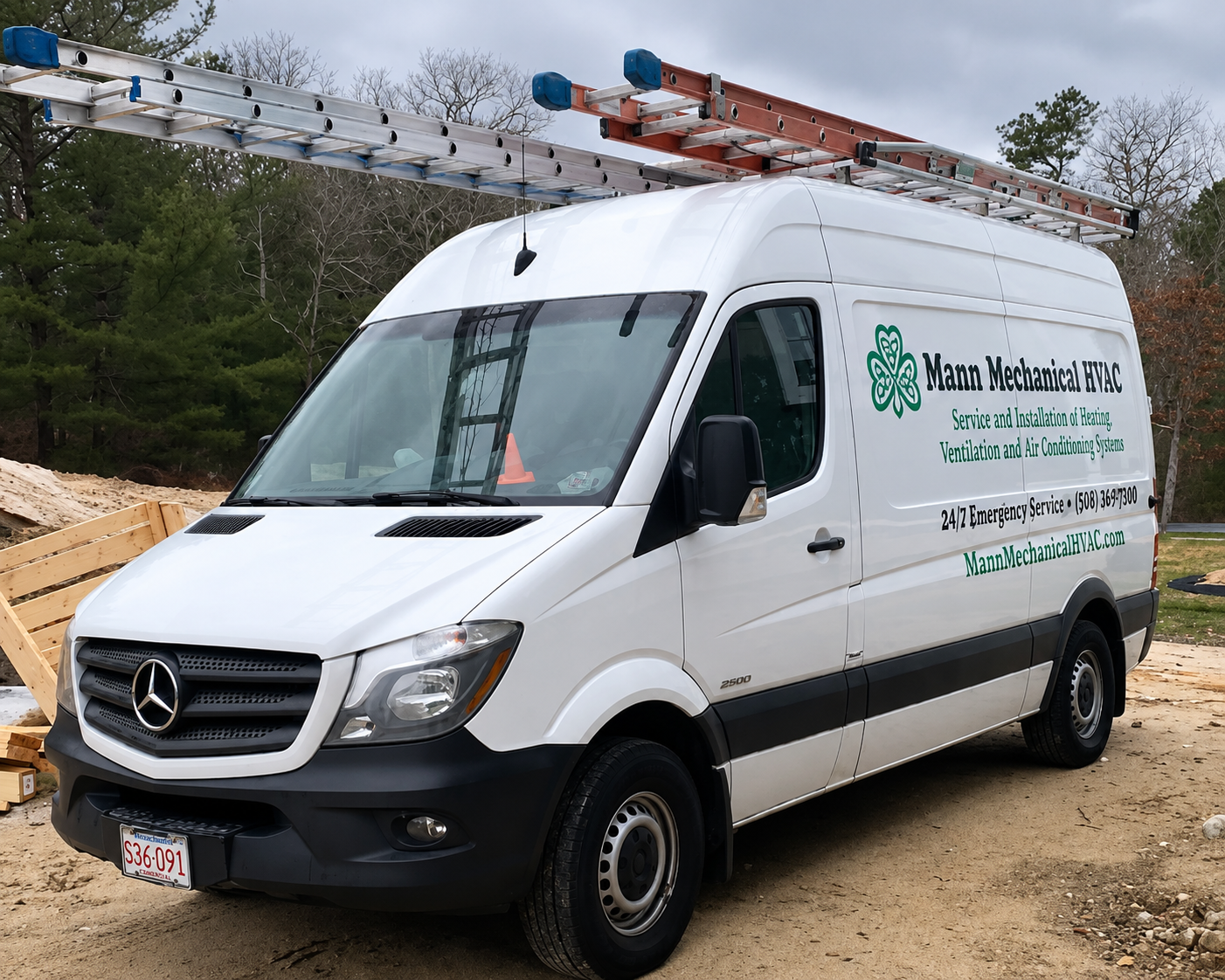 White Mercedes utility van with ladders on top parked at a construction site