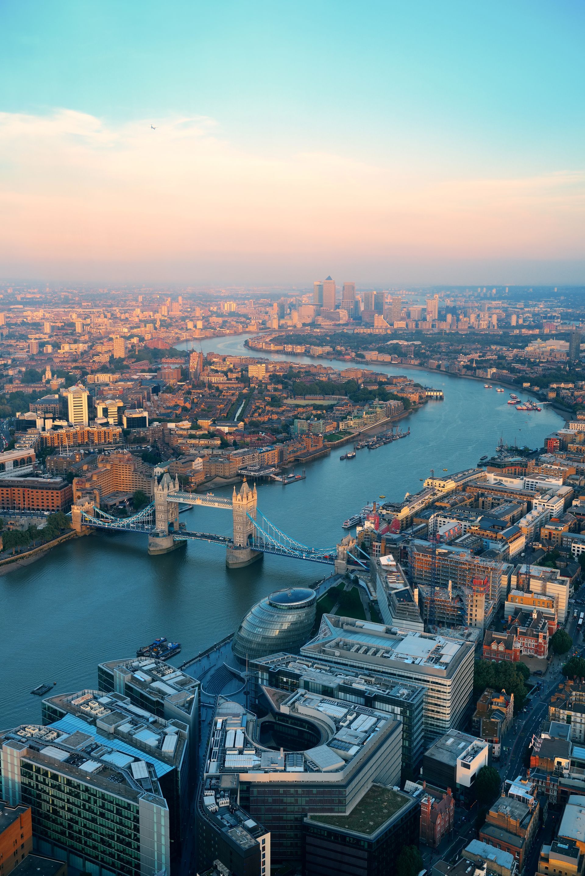 Aerial view of London, including Tower Bridge and the River Thames at sunset.