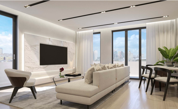 Modern living room with white marble accent wall, large windows, and a beige sofa.