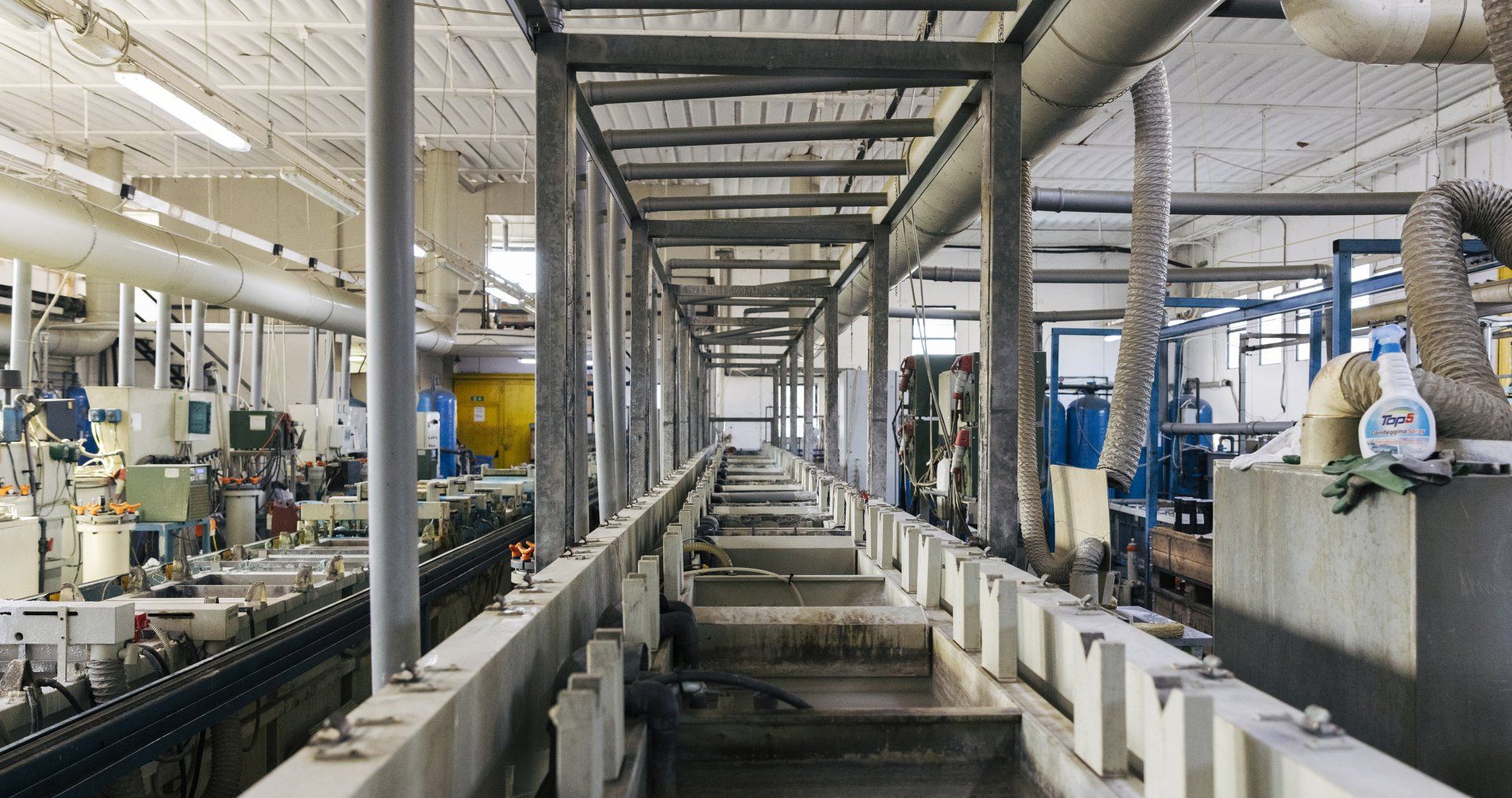 Interno industriale con lunga canalizzazione e tubi sospesi.