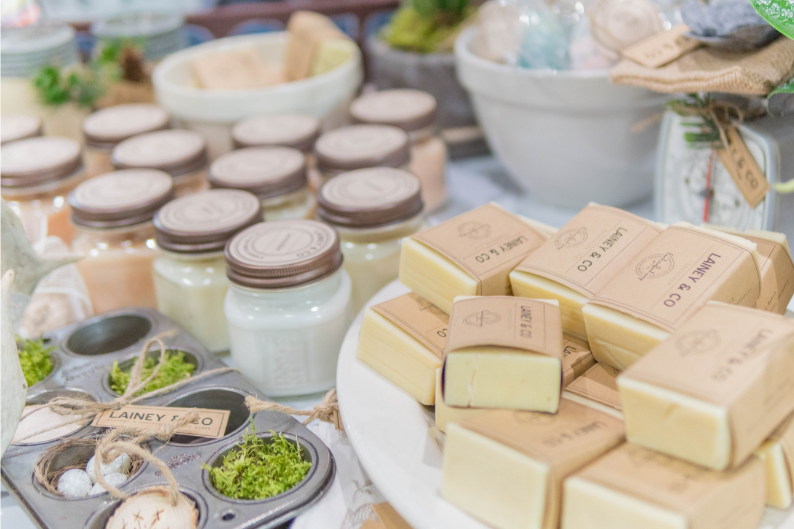 A table topped with a variety of soaps and candles.