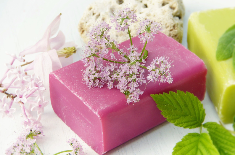 A pink soap bar with flowers on top of it