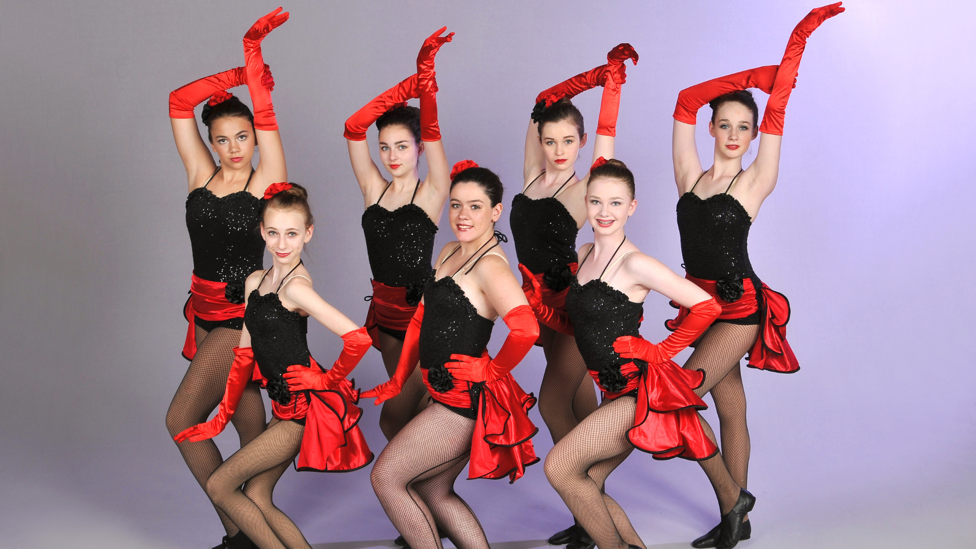 a group of dancers wearing red gloves and black dresses