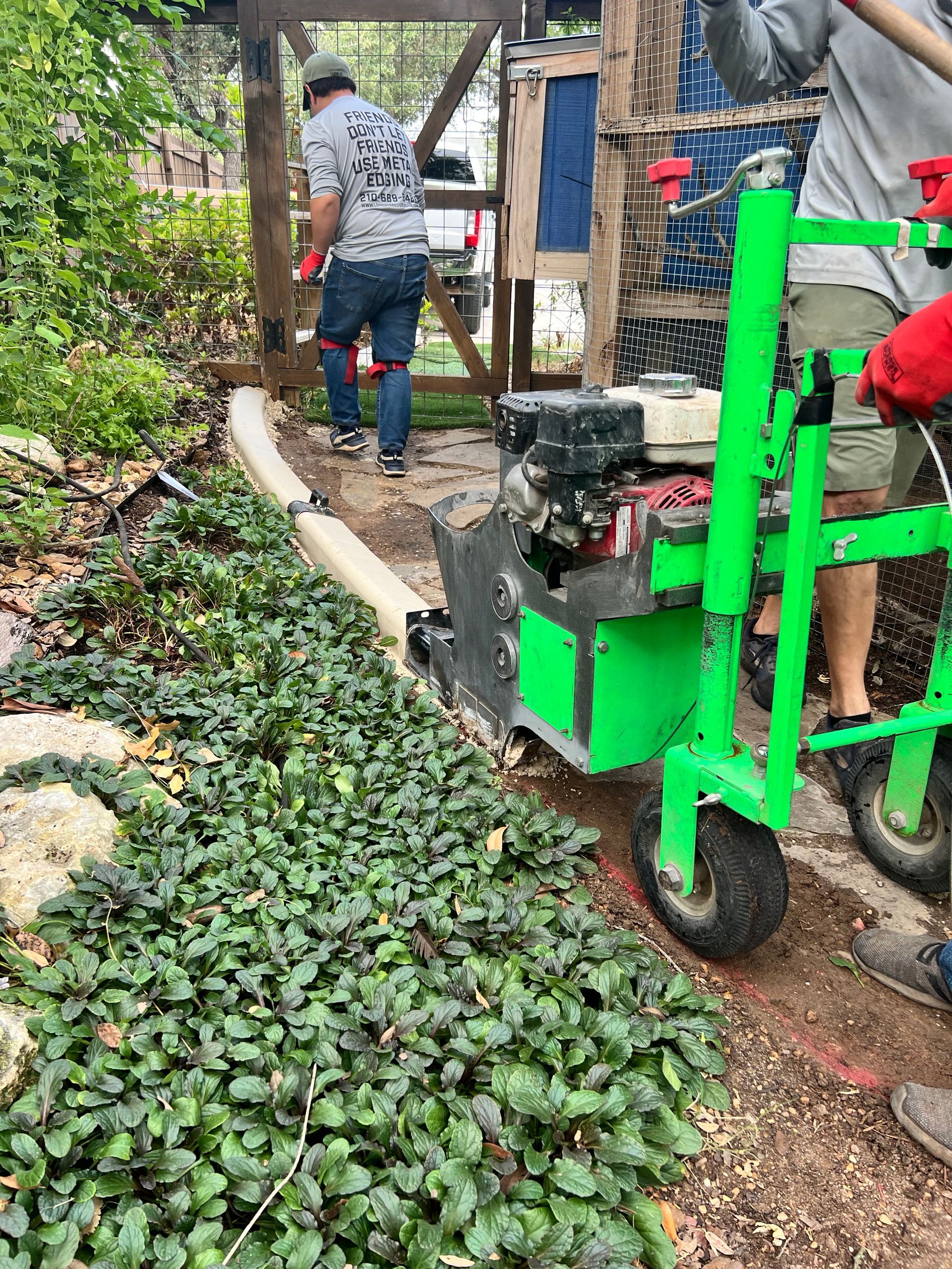 A green tractor is being used to dig a hole in the ground.