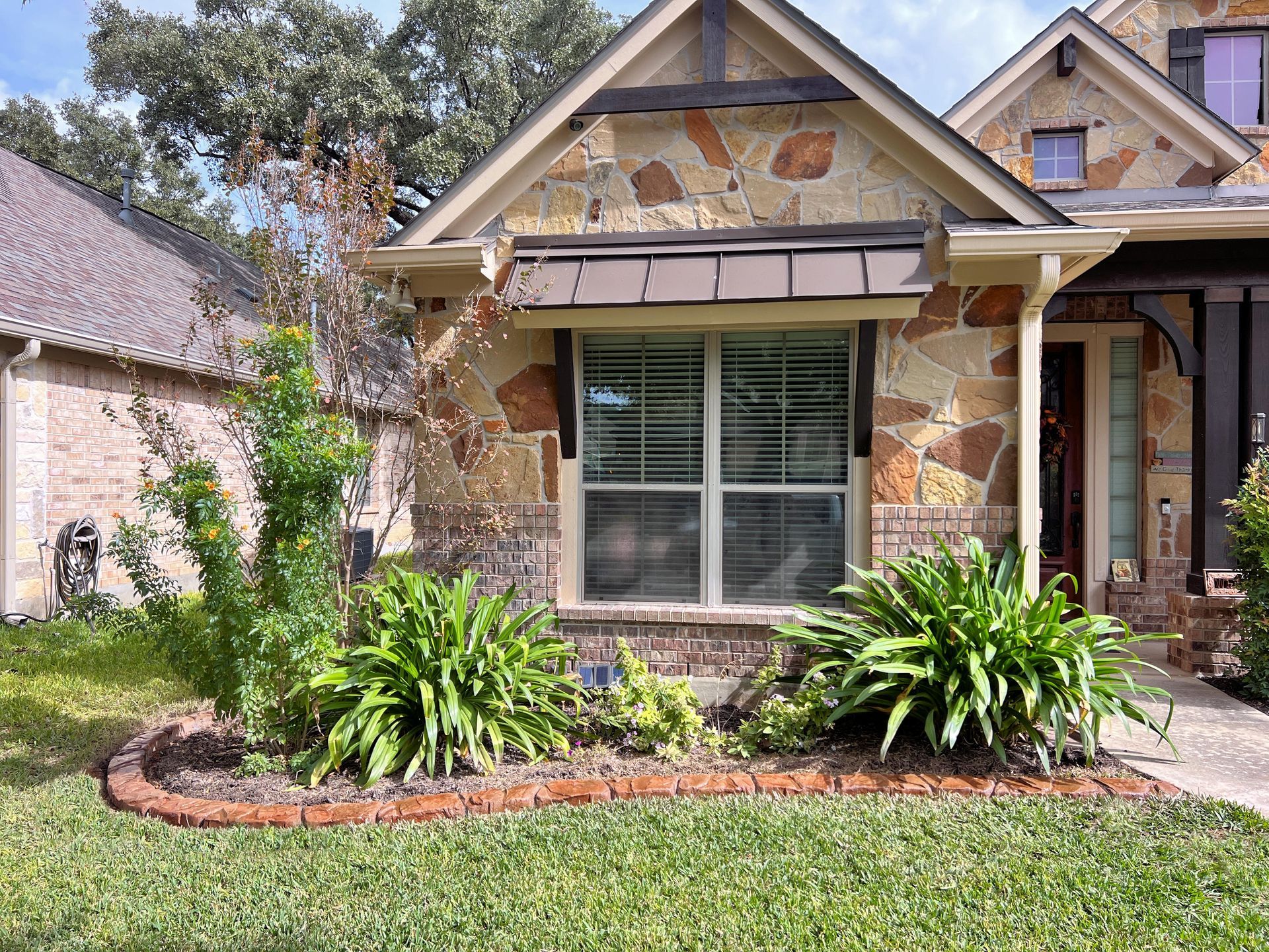 A house with a lot of plants in front of it.