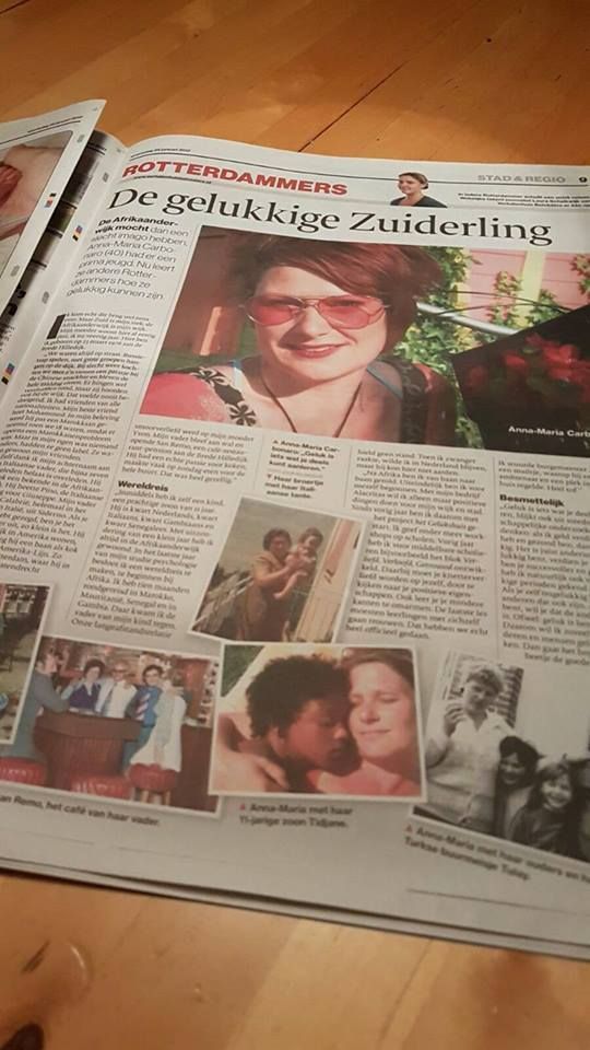 Een krantenpagina met koppen en diverse foto's, waaronder een groot portret van een lachend persoon met een rode bril.