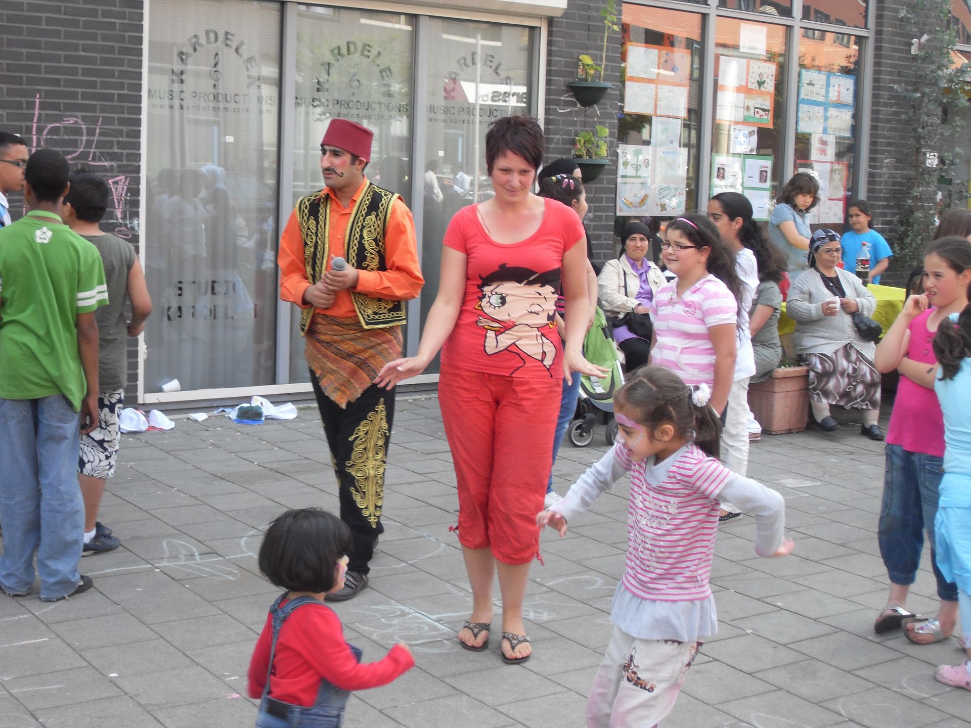 Mensen lopen en dansen op een stoep in de stad, voor winkels.