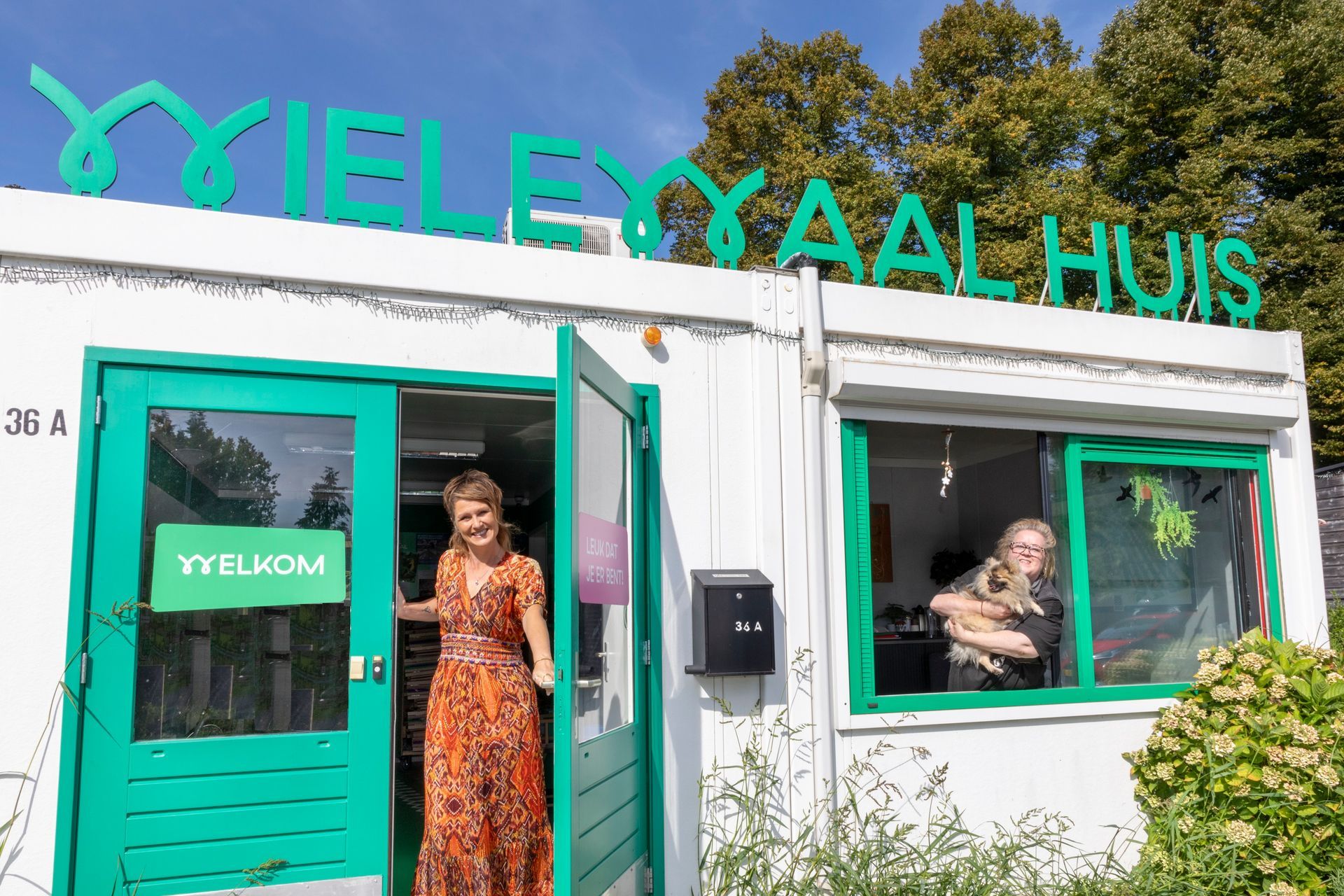 Winkelpui met turquoise accenten en twee personen zichtbaar binnen, met het opschrift 