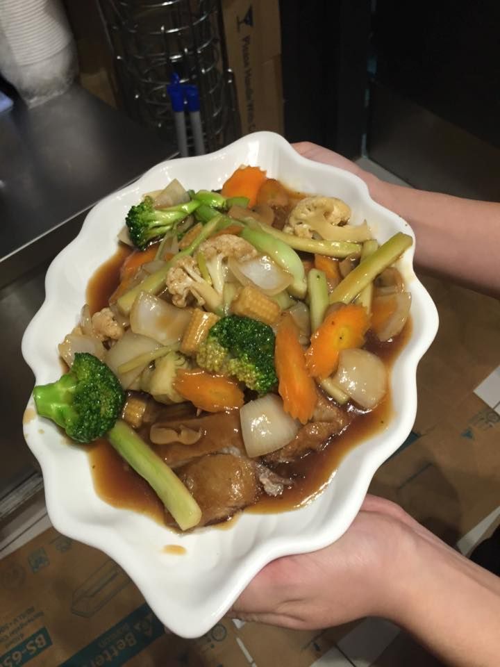 A Person is Holding a Plate of Vegetables in Their Hands — Red Lantern Chinese Restaurant In Palmerston City, NT