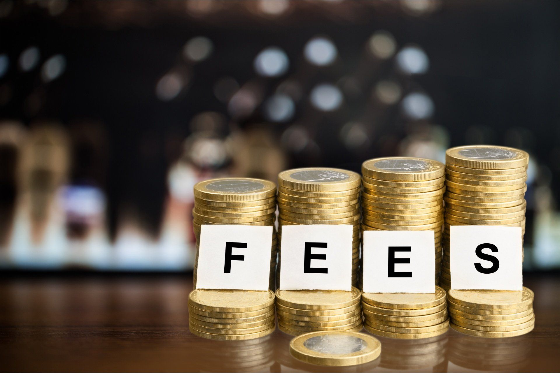 coins stacked with fees written on papers