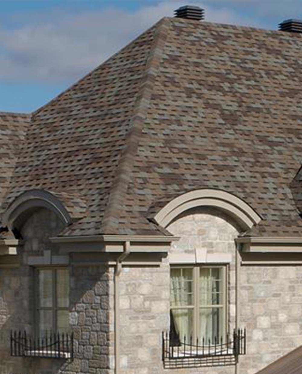 A house with a brown roof and arched windows