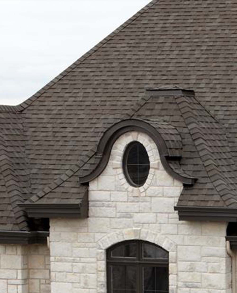 A house with a gray roof and a round window