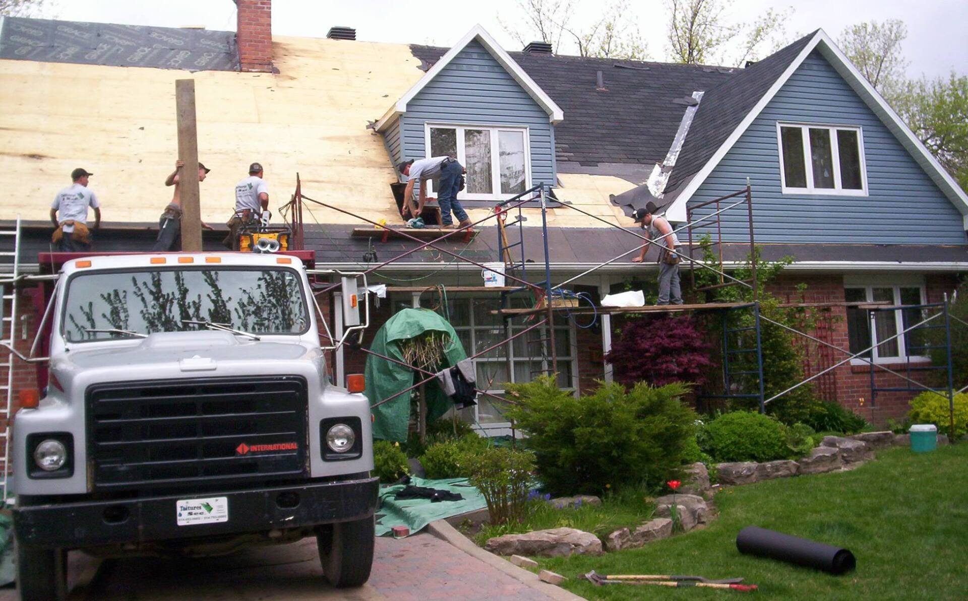A gm truck is parked in front of a house under construction