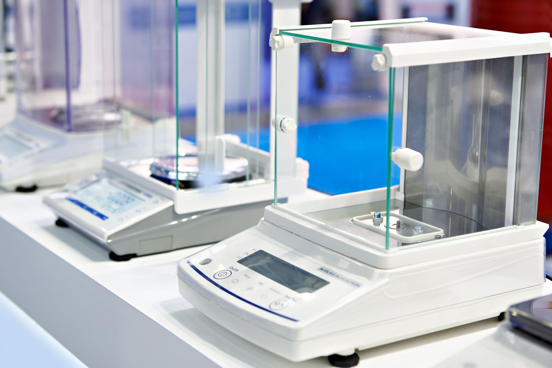Two digital laboratory scales on a countertop in a bright lab setting