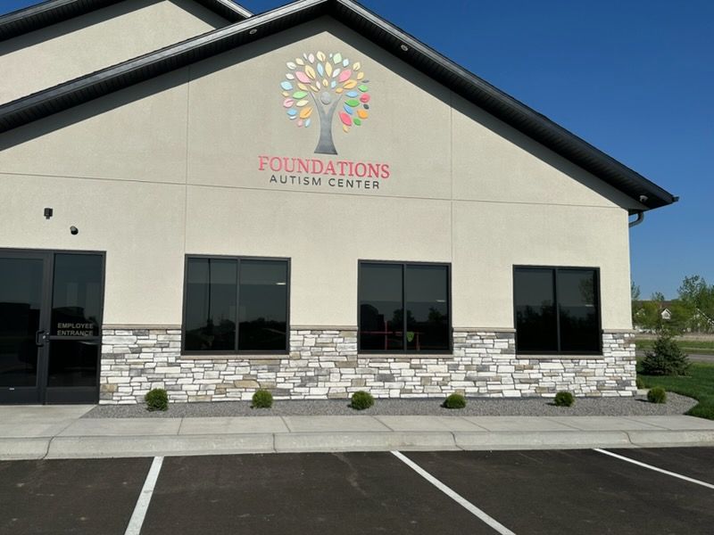 Front view of Foundations United Church building with stone facade and colorful logo above windows